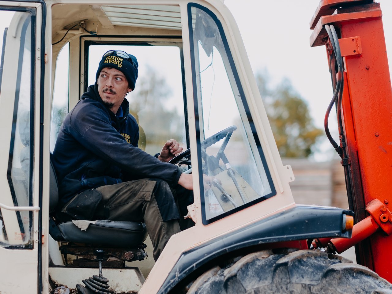 A portrait of a man in uniform driving a tractor